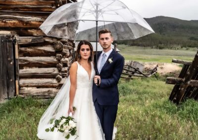 Ranch wedding in colorado videographer photographer storybook weddings rain dramatic bride and groom umbrella
