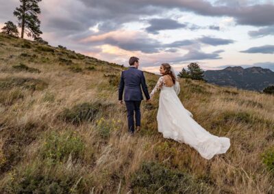 Ymca of the rockies wedding videography and photography by jeremiah bride and groom walk in the mountains at sunset